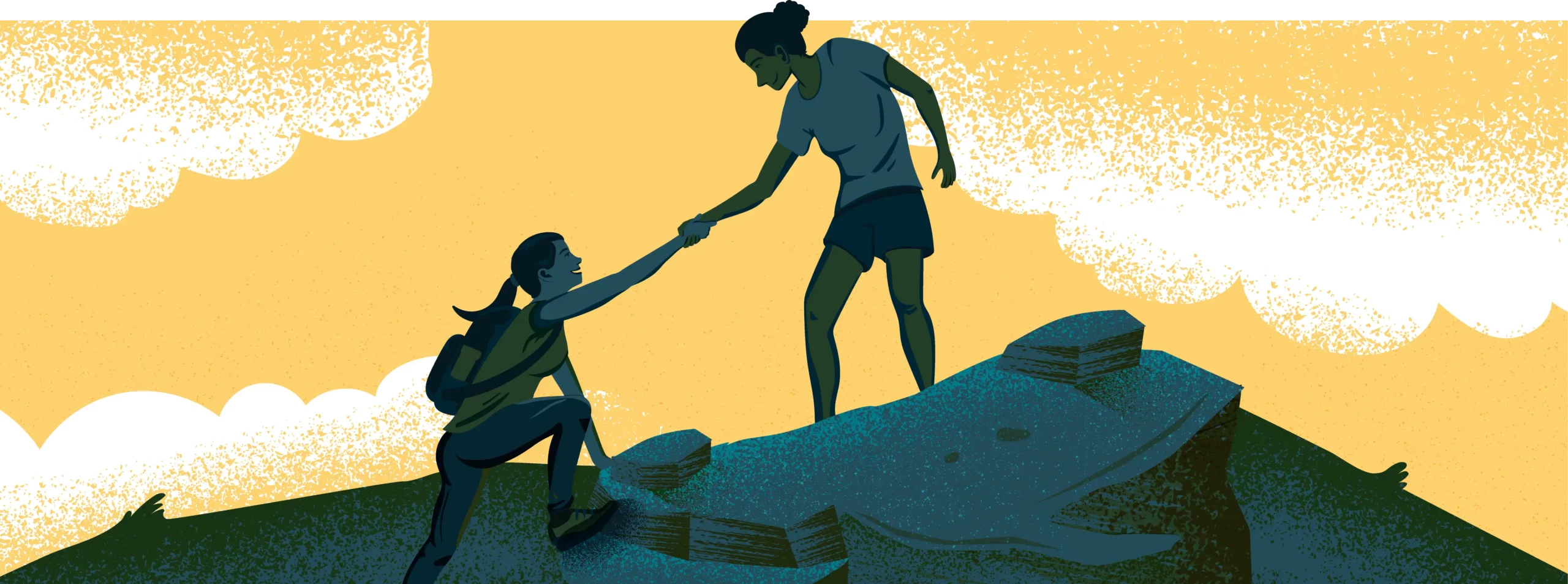 Woman helping another woman up a large rock